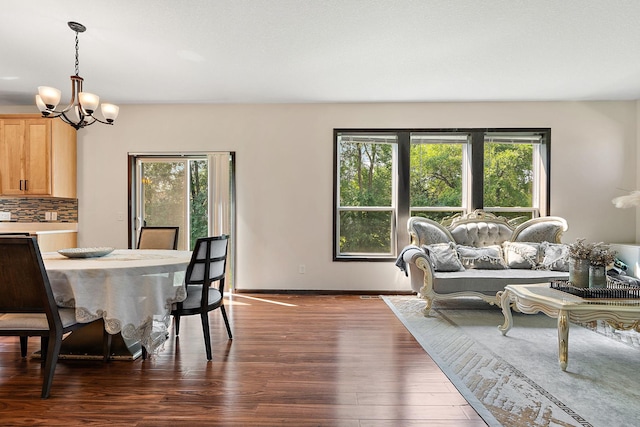 dining room with dark hardwood / wood-style flooring and a chandelier