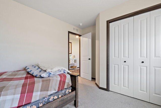 bedroom featuring light colored carpet and a closet