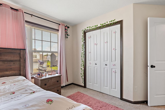 carpeted bedroom featuring a textured ceiling and a closet