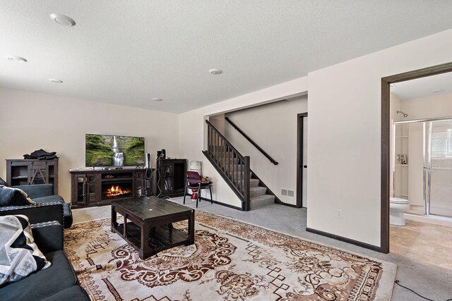 living room with plenty of natural light, a textured ceiling, and light carpet