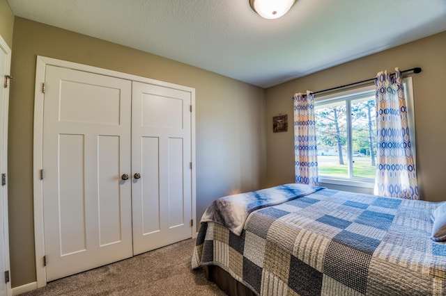 carpeted bedroom featuring a textured ceiling and a closet