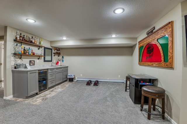 bar featuring light carpet, wine cooler, baseboard heating, and gray cabinetry