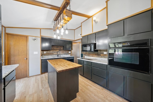 kitchen featuring light hardwood / wood-style flooring, backsplash, wood counters, black appliances, and a center island