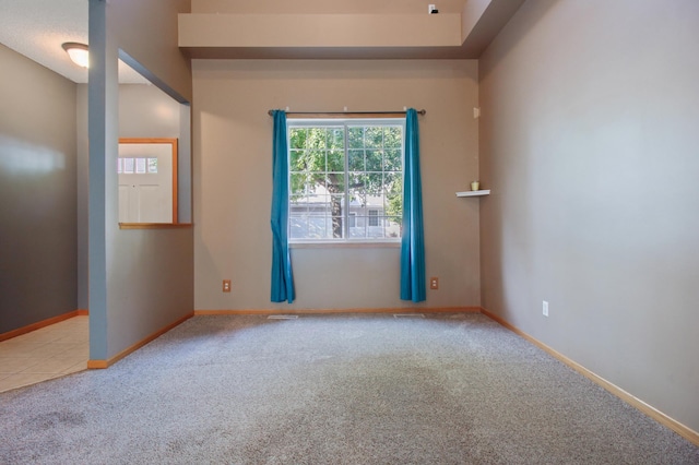 spare room featuring light carpet