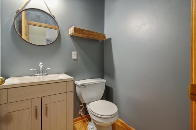 bathroom featuring wood-type flooring, vanity, and toilet