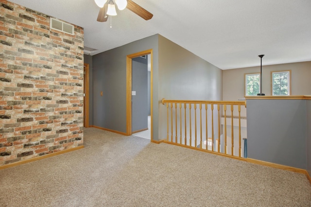 unfurnished room featuring light colored carpet, a textured ceiling, and ceiling fan