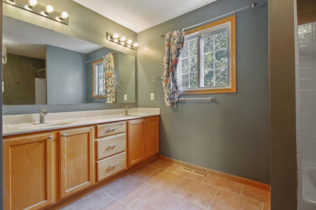 bathroom with vanity, bathing tub / shower combination, tile patterned flooring, and a textured ceiling