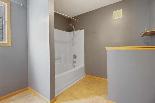 bathroom with a textured ceiling, bathtub / shower combination, and tile patterned floors