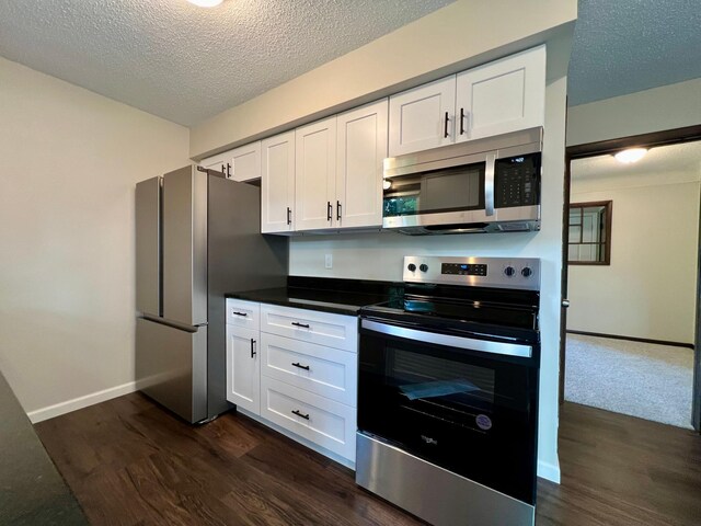 kitchen with white cabinets, a textured ceiling, appliances with stainless steel finishes, and dark hardwood / wood-style flooring