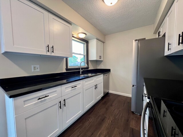 kitchen featuring white cabinets, a textured ceiling, stainless steel dishwasher, dark hardwood / wood-style floors, and sink