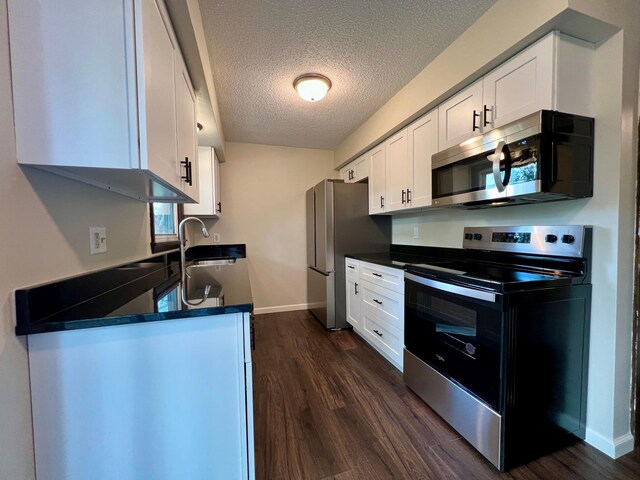 kitchen featuring white cabinets, a textured ceiling, appliances with stainless steel finishes, and dark hardwood / wood-style floors