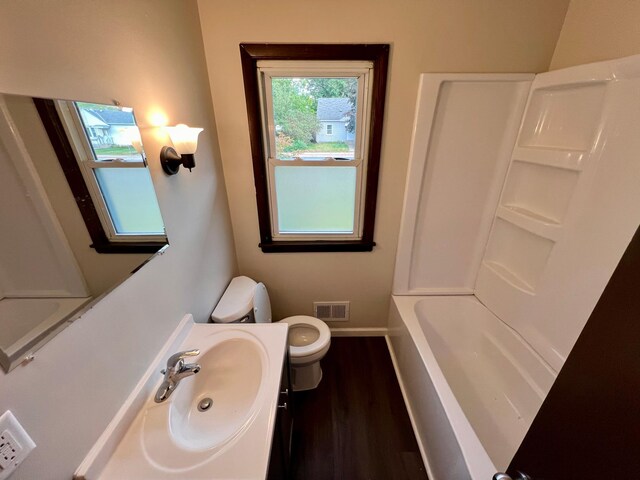 full bathroom with vanity, toilet,  shower combination, and hardwood / wood-style flooring