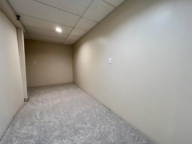 carpeted empty room with a drop ceiling