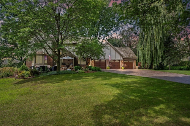 view of front of house featuring a garage and a lawn