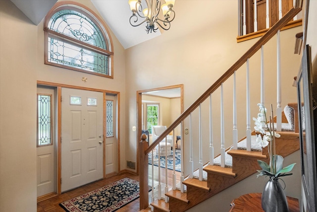 entrance foyer with hardwood / wood-style floors, a chandelier, and high vaulted ceiling