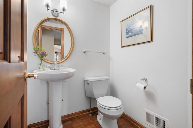 bathroom with parquet flooring and toilet