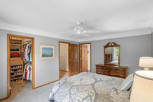 bedroom with a closet, ornamental molding, light colored carpet, a spacious closet, and ceiling fan