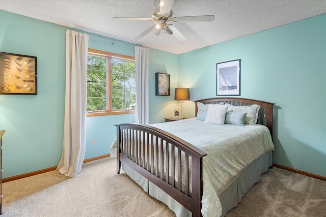 bedroom with a textured ceiling, carpet flooring, and ceiling fan