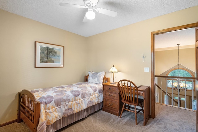 bedroom with a textured ceiling, ceiling fan with notable chandelier, and carpet flooring