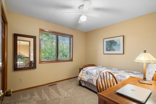 carpeted bedroom with ceiling fan and a textured ceiling