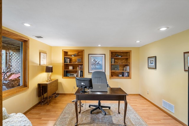 office area featuring built in features and light hardwood / wood-style flooring