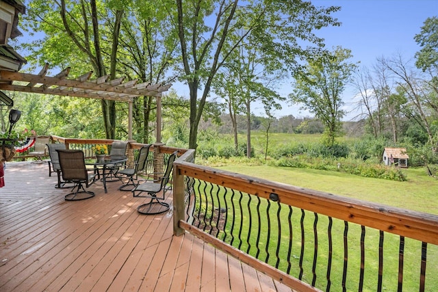 wooden deck with a yard and a pergola