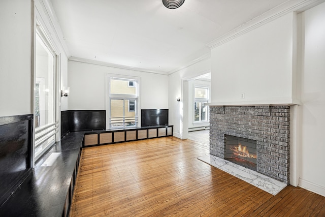 living room with a brick fireplace, light hardwood / wood-style flooring, and ornamental molding