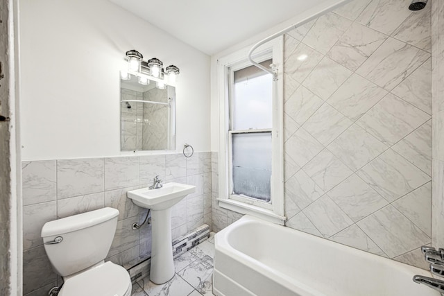 full bathroom with tiled shower / bath combo, tile walls, toilet, and sink