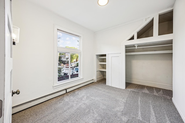 unfurnished bedroom with carpet floors and a baseboard heating unit