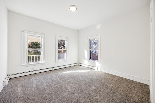 empty room with a baseboard heating unit and carpet flooring