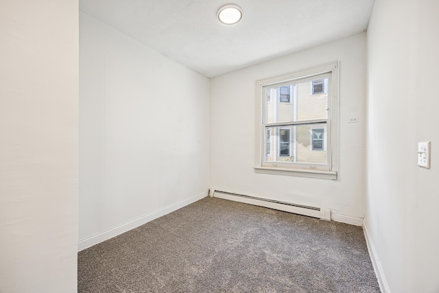 carpeted empty room featuring baseboard heating