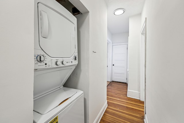 laundry room with light wood-type flooring and stacked washer and dryer