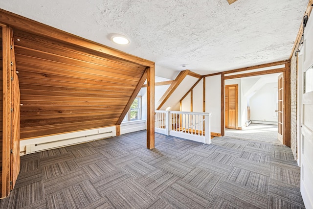 bonus room featuring dark carpet, lofted ceiling, a textured ceiling, and baseboard heating