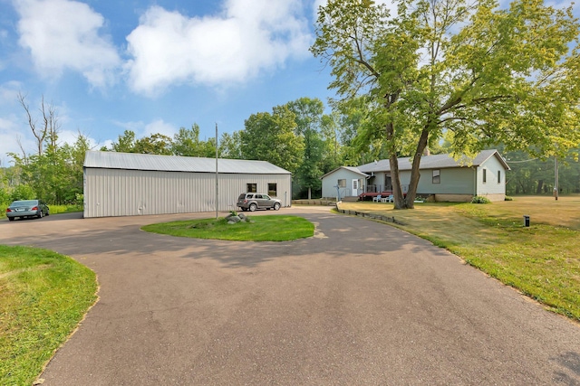 view of front of property featuring a front yard and an outbuilding