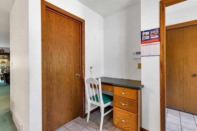 office space with built in study area and light tile patterned flooring