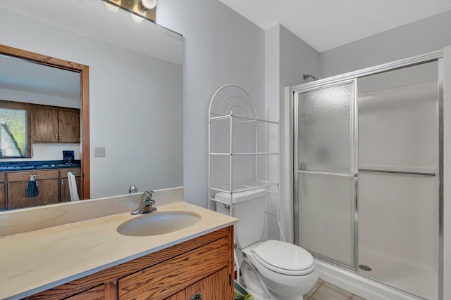 bathroom featuring vanity, toilet, tile patterned flooring, and a stall shower