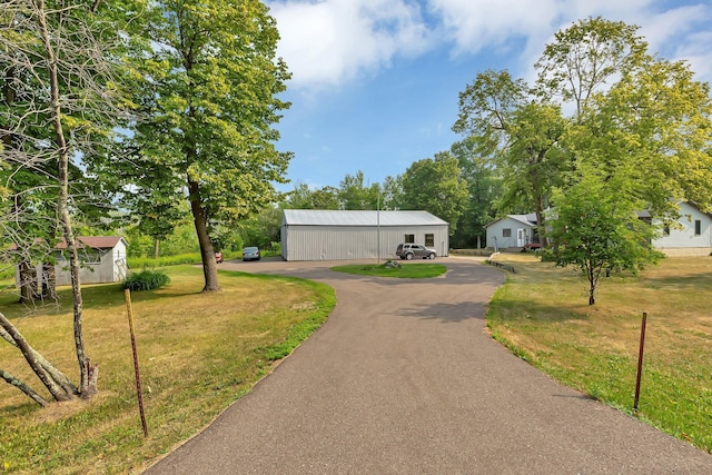 view of property's community featuring a yard and an outbuilding