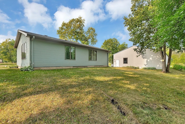 back of property featuring a yard and an outbuilding