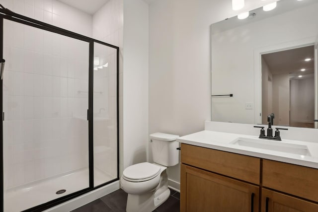 bathroom with tile patterned floors, vanity, toilet, and a shower with shower door