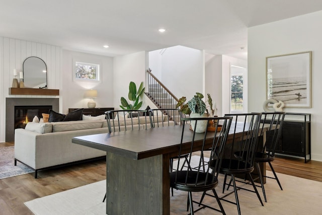 dining room featuring a tile fireplace and light hardwood / wood-style floors