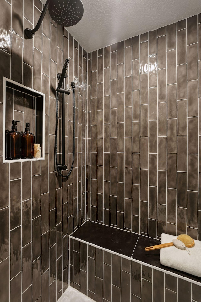 bathroom featuring a tile shower and a textured ceiling