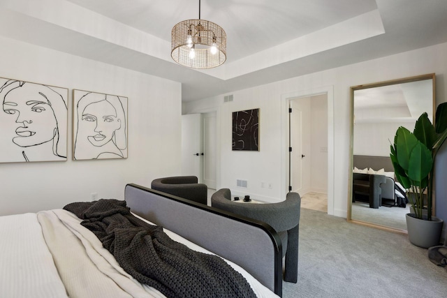 bedroom with light carpet and a tray ceiling