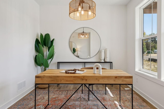 office space with baseboards, visible vents, and a notable chandelier