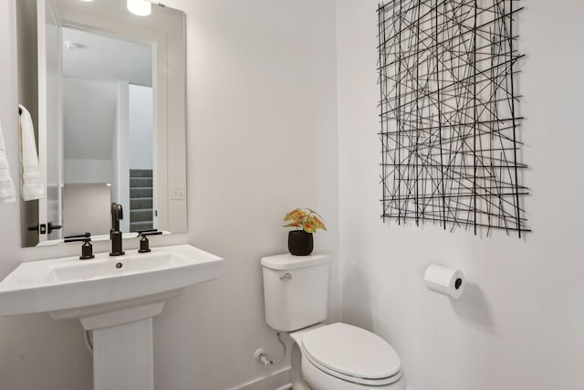 half bath with toilet and baseboards