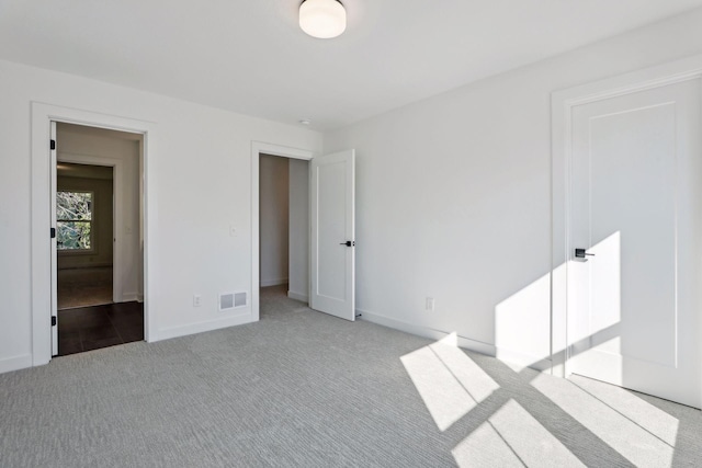 unfurnished bedroom with baseboards, visible vents, and light colored carpet