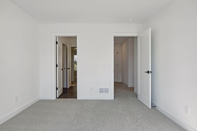 unfurnished bedroom featuring carpet, visible vents, and baseboards