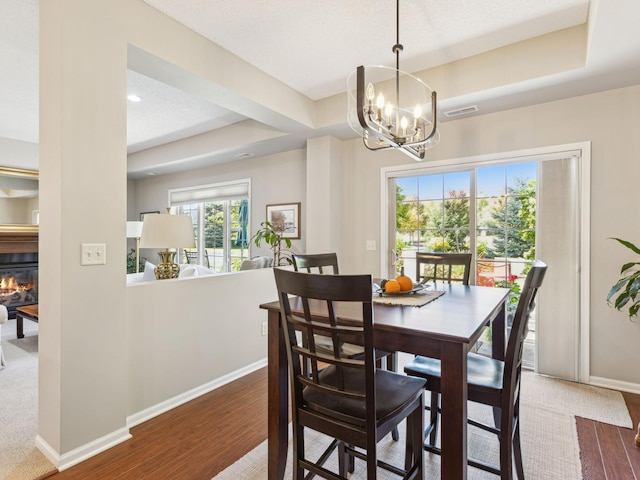 dining space featuring hardwood / wood-style floors, a textured ceiling, and a chandelier