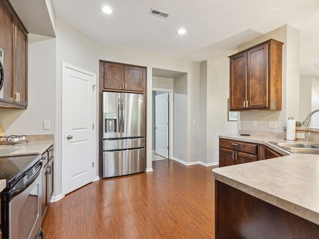 kitchen with dark hardwood / wood-style flooring, a textured ceiling, sink, and stainless steel refrigerator with ice dispenser