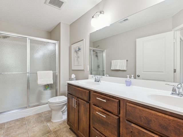 bathroom with vanity, toilet, tile patterned floors, and an enclosed shower