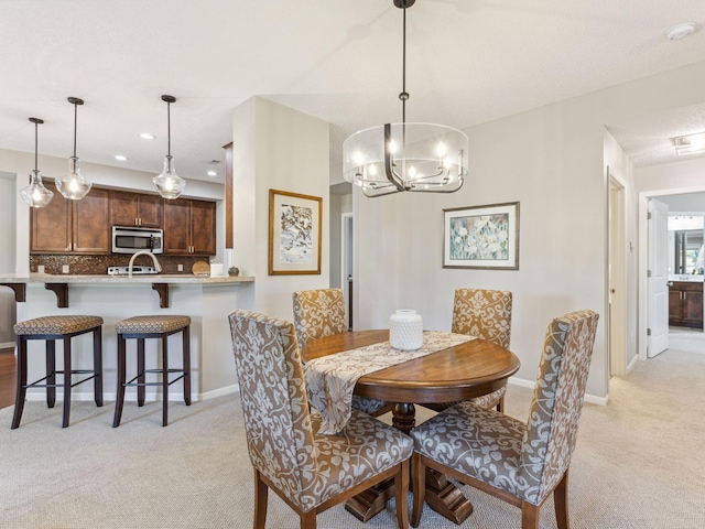 dining space featuring light carpet and an inviting chandelier